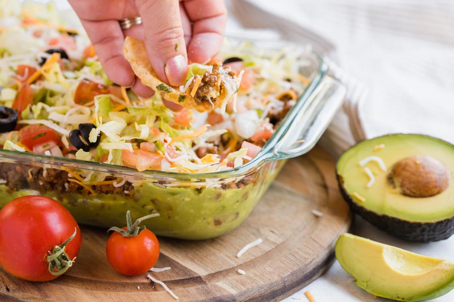 dipping a pork rind in a taco dip with low carb ingredients