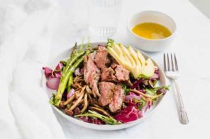 Grilled steak salad, sitting on a table ready to eat