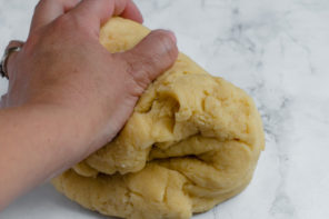 pot pie turnover dough being kneaded with a hand