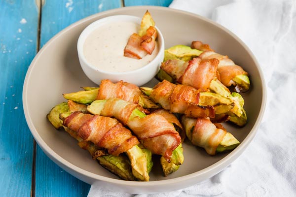 dipping a keto avocado fry into ranch dressing