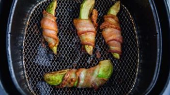 cooked bacon wrapped avocoado in an air fryer basket
