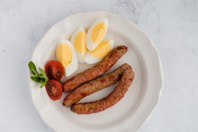 breakfast sausages on a plate with hardboiled eggs