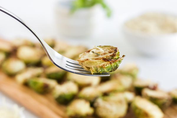 holding a crispy brussels sprout with a fork