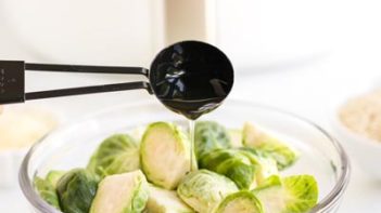 pouring olive oil onto fresh brussels sprouts