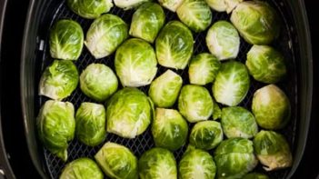 fresh brussels sprouts cut side down in the air fryer basket