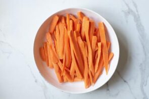 A bunch of carrot sticks on a plate.
