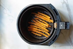 Roasted carrots in an air fryer basket.