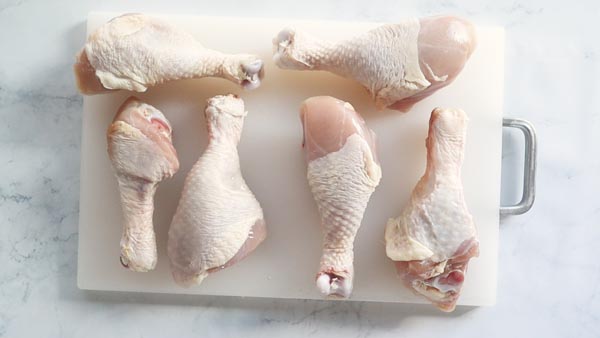 a cutting board with chicken legs