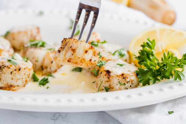 picking up a scallop with a seafood fork