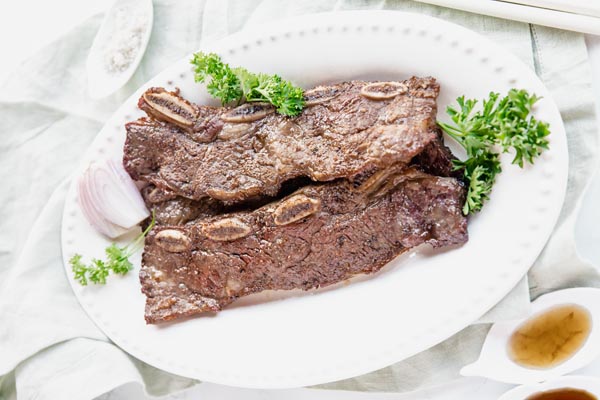 thin cut short ribs on a plate with parsley and shallot