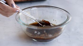 whisking marinade in a glass bowl