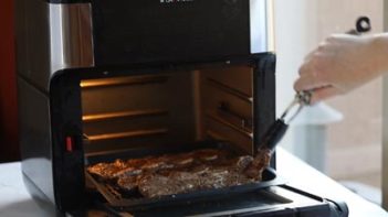 turning short ribs with tongs in the air fryer
