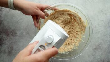 Mixing cookie ingredients in a bowl with an electric mixer.