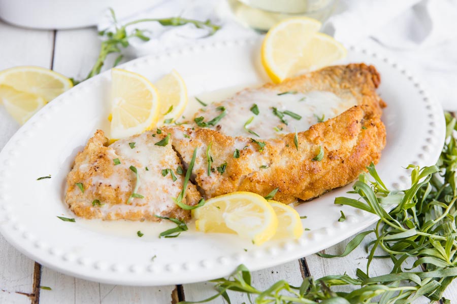 juicy tender rockfish fish fried in an almond flour crust and drizzled with a lemon cream sauce and topped with tarragon and lemon slices