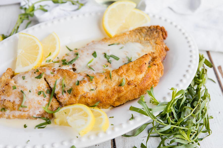 close up of juicy rockfish fried to perfection with a golden almond flour coating and sprinkled tarragon on top