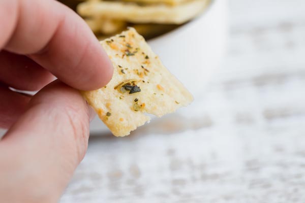 holding a thin, cripsy cracker