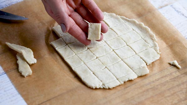 holding a square of cracker dough