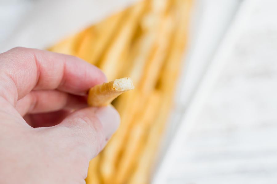 holding a half bitten french fry to show the inside