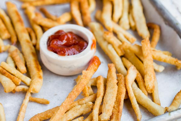 french fries scattered on a tray with ketchup