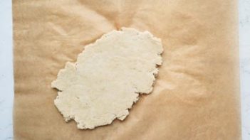 flatten dough on a piece of parchment paper