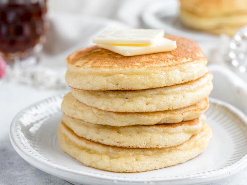 A stack of almond flour pancakes with two pats of butter on top.