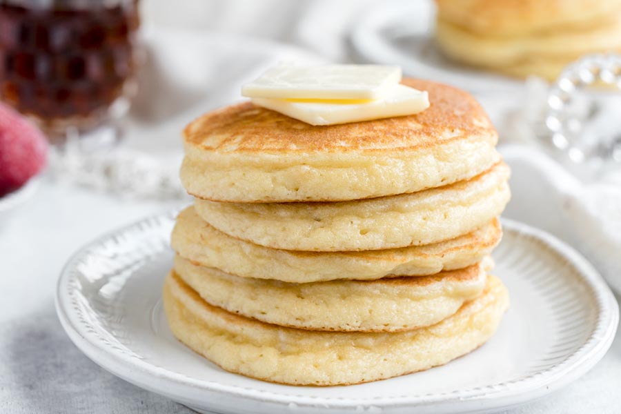 A stack of almond flour pancakes with two pats of butter on top.