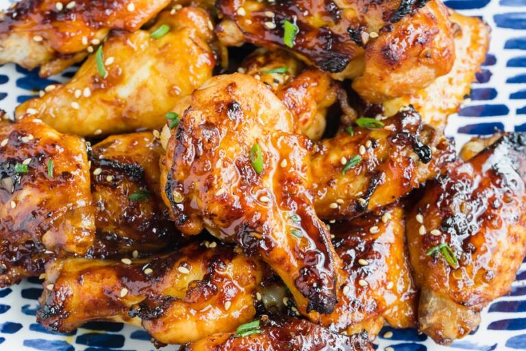Sticky chicken wings coated in a spicy, sweet sauce and topped with sesame seeds and sliced green onions.