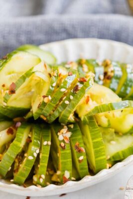 green cucumber salad topped with sesames and red pepper flakes