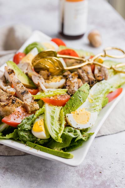 chicken salad with a bottle of sherry vinegar in the background