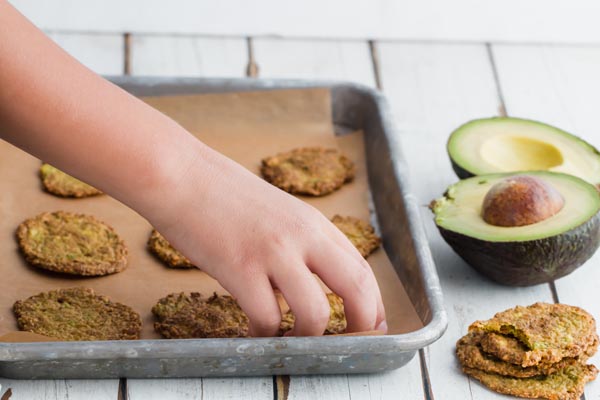 a kid grabbing a baked chip from the tray