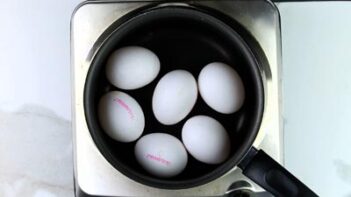 Six eggs in a saucepan filled with water.