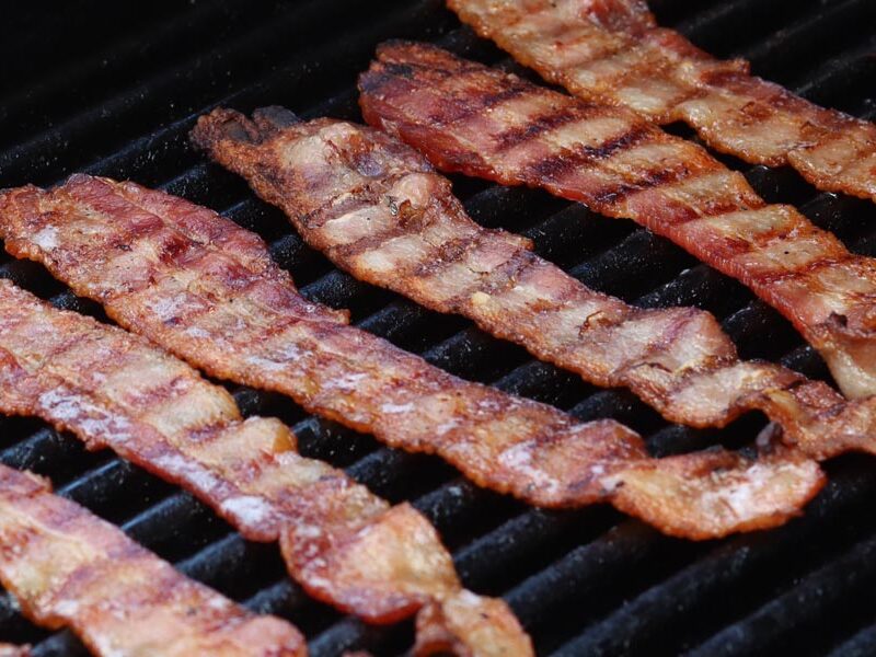 juicy crispy bacon cooking on a grill