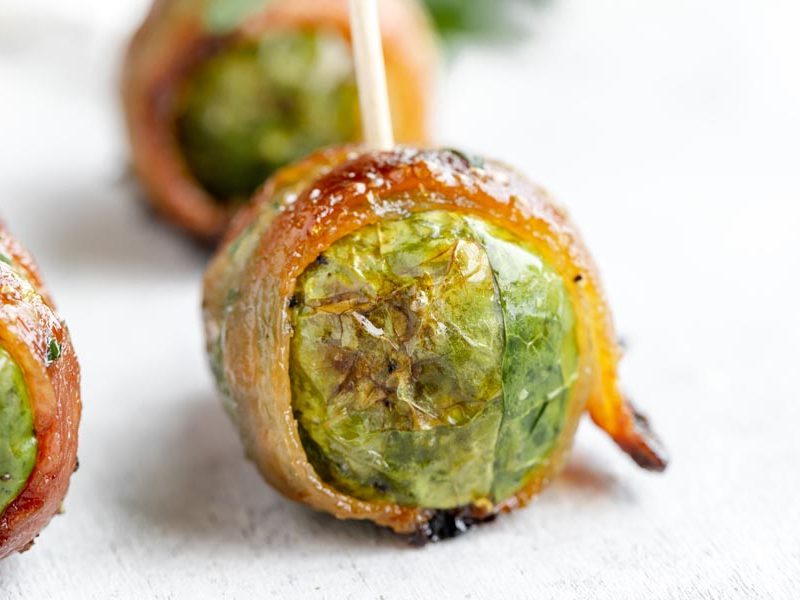 a juice bacon wrapped brussel srpout with a tooth pick through it