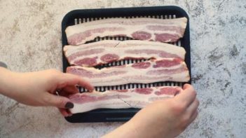 laying down bacon on an air fryer tray