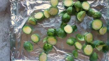 brussels sprouts cut in half on a foil lined baking sheet