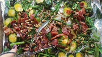 tossing the dressing over the bacon and brussels sprout salad