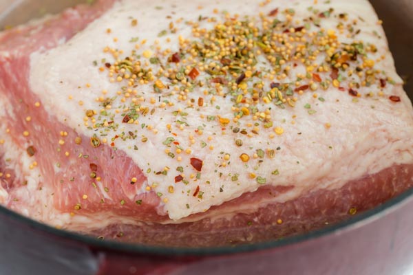 seasoning on a beef brisket in a pot