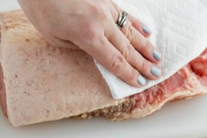 patting a brisket dry with a paper towel