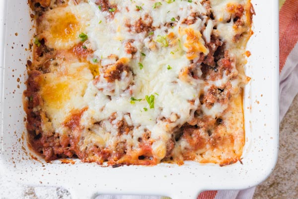 baked pasta dish in a white pan covered with cheese