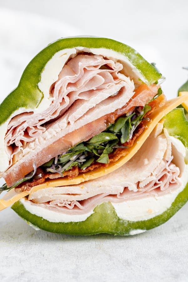 layers of lunch meat, bacon, sprouts and tomato fill a bell pepper