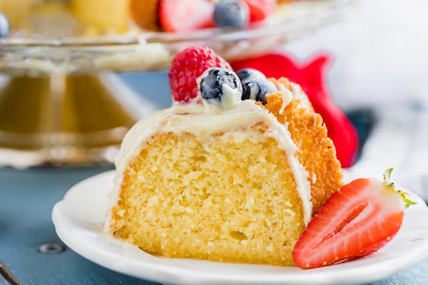 a slice of spongy vanilla cake topped with berries