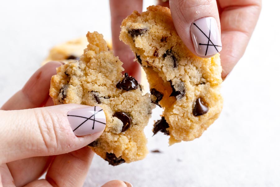 pulling apart a chocolate chip cookie with fingers