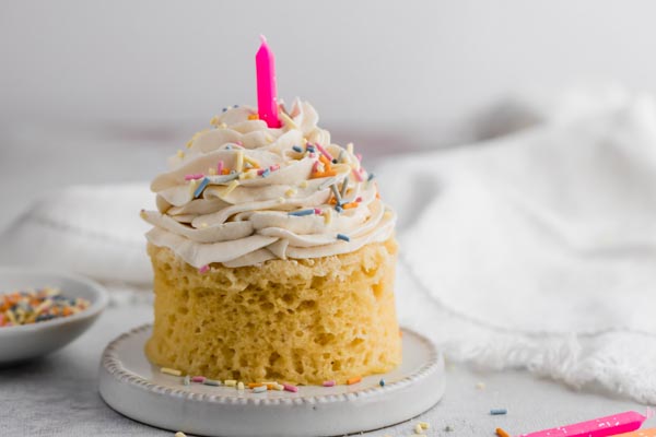 a mug cake frosted with sprinkles on top