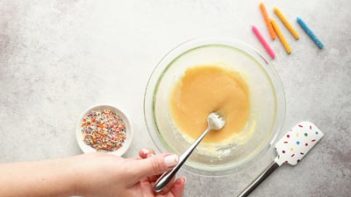 mixing cake batter in a small pyrex bowl with a fork