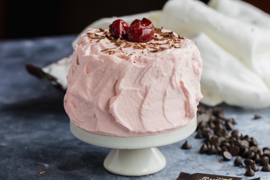 a creamy frosted cake with chocolate chips scattered near