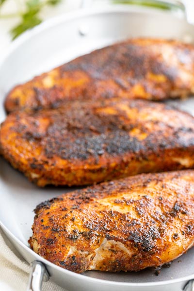 Blackened chicken with a juicy, charred outer layer in a grill pan.