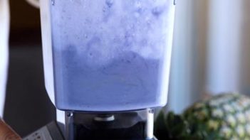 a blue frozen drink blending in a blender