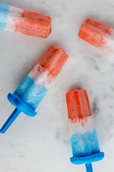 four patriotic popsicles on a marble counter