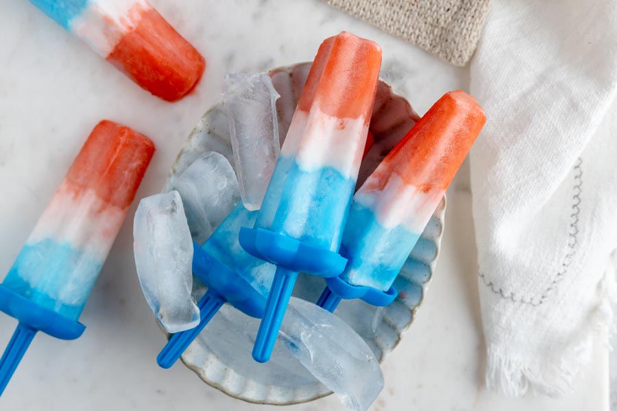 a bunch of bomb pops in a tray with ice cubes