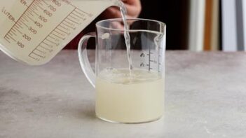 pouring a clear liquid in a measuring cup